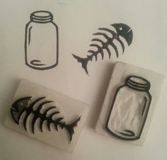 three stamps with fish, jar and skeleton in them on a white surface next to each other