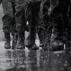 black and white photograph of soldiers walking in the rain