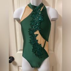 a green and gold leotard with sequins on it