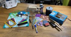 the table is cluttered with craft supplies such as markers, pencils and ink