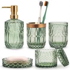 green glass bathroom accessories including toothbrushes and soap dispenser