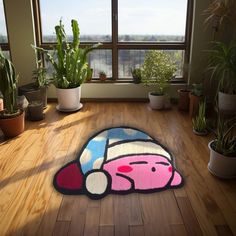 a cartoon character rug is on the floor in front of a window with potted plants