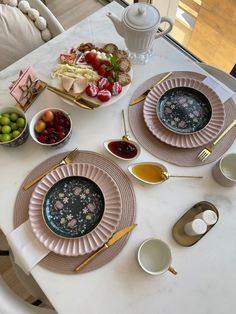 the table is set with plates and bowls of food