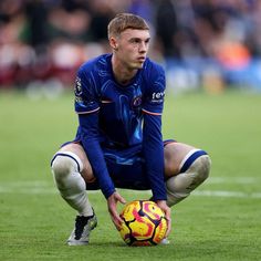 a man kneeling down with a soccer ball