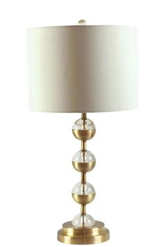 a lamp with three balls on it and a white lampshade above the lamp