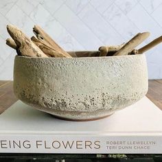 a bowl filled with sticks on top of a book