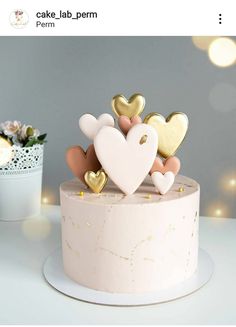 a cake decorated with gold and white hearts