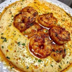 a white plate topped with grita covered in shrimp