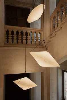 several lights hanging from the ceiling in a room with wooden railings and balconies