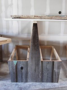 a wooden structure sitting on top of a floor next to a table and chair in a room