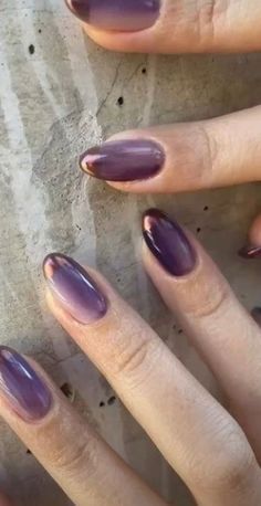 two hands with purple nail polish on them