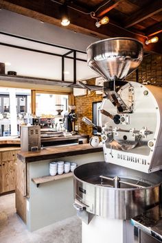 a coffee machine sitting in the middle of a kitchen next to a counter with cups on it