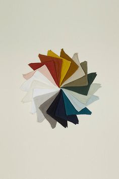 a bunch of different colors of cloths on a white surface with one color in the middle