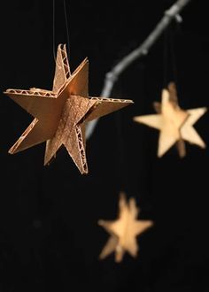 three wooden stars hanging from strings on a black background with the words interest written below them