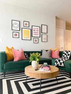 a living room filled with green couches and pictures on the wall above their coffee table