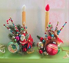 two candles are decorated with christmas decorations