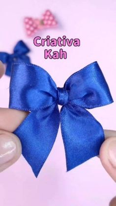 a person holding a blue bow in their hand with the words criativva kah on it