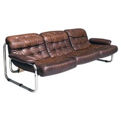 a brown leather couch sitting on top of a metal frame