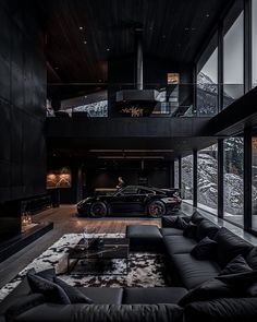 a living room filled with black furniture and a car parked in front of the window