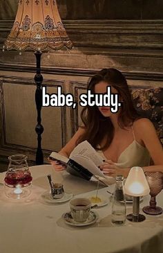 a woman sitting at a table reading a book with the caption babe, study