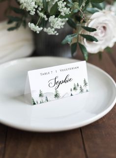 place cards on a plate with flowers in the background