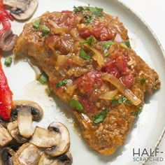 a white plate topped with meat covered in sauce next to sliced mushrooms and bell peppers