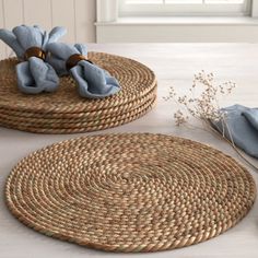 two round placemats with blue flowers on them, sitting on a white table