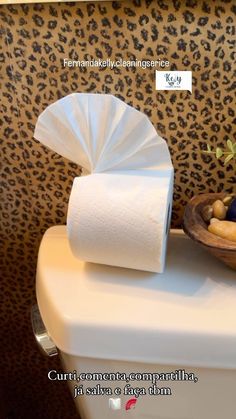 the toilet paper is next to a bowl with fruit on it