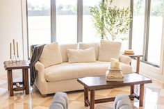 a living room with two couches and a coffee table in front of large windows