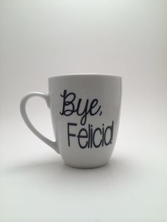 a white coffee cup with the words bye, felicid written in black ink