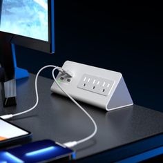 an electronic device is plugged in to a computer monitor on a desk with a phone nearby