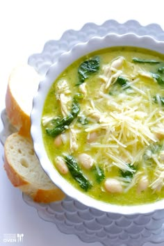 a white bowl filled with soup next to two slices of bread