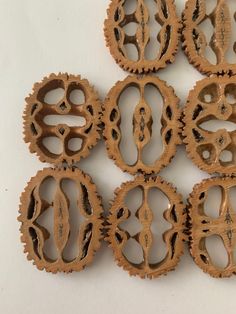 six wooden gears are arranged on a white surface