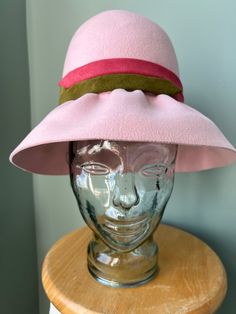 "From my longtime personal collection comes this stylish, powder pink hat by Christian Dior Chapeaux, circa 1960s Crafted from soft, supple fur felt, with a high, pleated crown, a wide brim that is subtly gathered from ear to ear (but not in back), and a striking band of dusty rose and olive green suede leather  Easily shaped for a variety of looks and vibes Matching powder pink interior sweat band, a designer label the reads \"Christian Dior chapeaux Paris-New York\" and the inside crown is sta Pink Adjustable Brimmed Cloche Hat, Retro Pink Brimmed Hat, Pink Brimmed Fedora For Winter, Retro Pink Wide Brim Hat, Spring Retro Cloche Hat With Wide Brim, Pink Fedora Felt Hat For Kentucky Derby, Pink Cloche Hat With Curved Brim, Pink Fedora For Kentucky Derby, Pink Wide Brim Fedora For Kentucky Derby