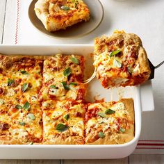 a white casserole dish filled with cheese and tomato sauce