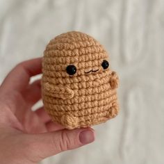 a crocheted toy is held up in the palm of someone's hand