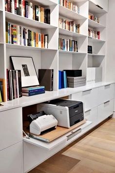 a printer on a desk in front of bookshelves