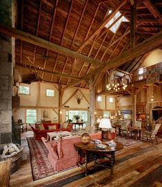 a living room filled with lots of furniture and wooden flooring next to a fire place