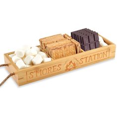 a wooden box filled with marshmallows and brownies on top of a white background