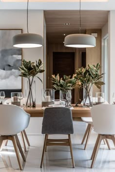 a dining room with white chairs and wooden table