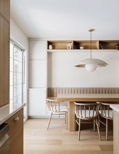 a dining room table and chairs in front of a book shelf