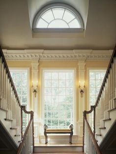 an empty staircase leading up to a window with a bench in the middle and windows above it