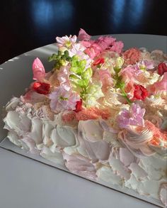 a white cake with pink and green flowers on it