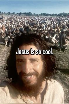 a man with long hair and beard standing in front of a large crowd that says jesus is so cool