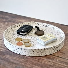 a cell phone and some coins on a tray