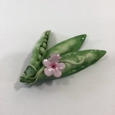 two peas with pink flowers on them are sitting next to each other in the shape of pea pods