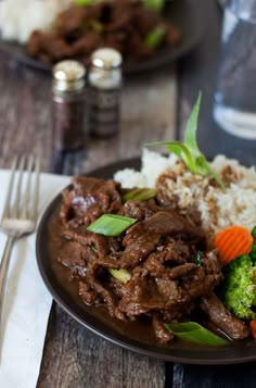 a plate with beef, broccoli and carrots on it next to rice