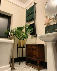 a white toilet sitting next to a bath tub under a bathroom mirror above a sink