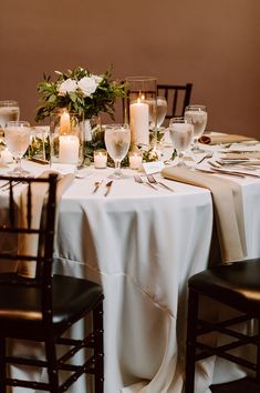 the table is set with white flowers and candles for an elegant wedding reception or special event