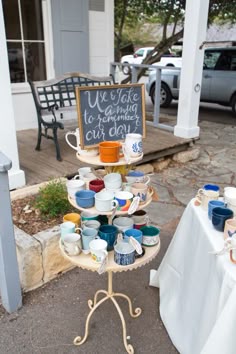 a table with cups and saucers on it in front of a sign that says we wake to a morning out down